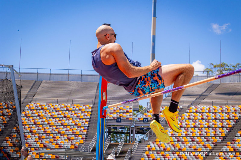 Masters athlete clearing the high jump bar
